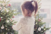 Chica decorando árbol de Navidad - foto de stock