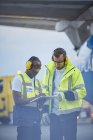 Contrôleurs aériens avec presse-papiers parlant sur l'aire de trafic de l'aéroport — Photo de stock