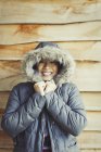 Portrait smiling woman wearing fur hood coat outside cabin — Stock Photo