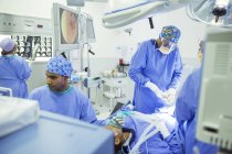 Surgeons performing surgery in operating room — Stock Photo