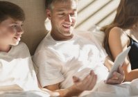 Father and son using digital tablet in bed — Stock Photo
