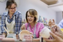 Mature woman painting pottery in studio — Stock Photo