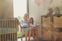 Schwangere Mutter und Tochter lesen im Kinderzimmer Märchen — Stockfoto