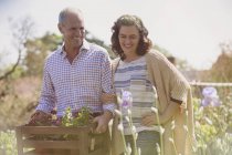 Sorridente coppia shopping per fiori in giardino vivaio piante soleggiate — Foto stock