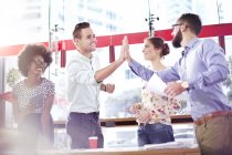 Business people high five in meeting at modern cafe — Stock Photo