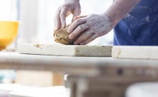 Старший человек литья глины в мастерской керамики — стоковое фото