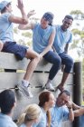Team feiert an Wand auf Bootcamp-Hindernisparcours — Stockfoto
