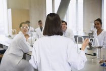 Female college student leading study group in science laboratory classroom — Stock Photo