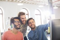 Smiling casual businessmen taking selfie in office — Stock Photo