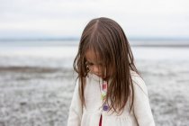 Morena menina olhando para baixo na praia — Fotografia de Stock