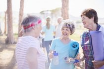 Старшие женщины разговаривают после занятий йогой в солнечном парке — стоковое фото