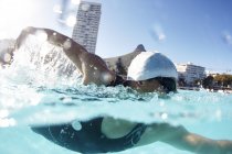 Schwimmerin schwimmt in sonnigem Schwimmbad — Stockfoto