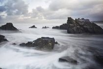 Océano de larga exposición girando alrededor de rocas, Devon, Reino Unido - foto de stock