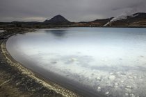 Gelo stagno acqua con colline sullo sfondo — Foto stock