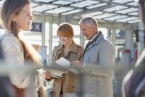 Business people reviewing paperwork in airport — Stock Photo