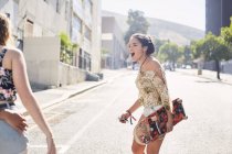 Adolescente avec planche à roulettes sur rue urbaine ensoleillée — Photo de stock