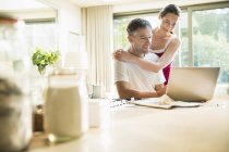 Casal usando laptop na cozinha da manhã — Fotografia de Stock