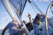 Männer segeln Anpassung Takelage und Segel auf Segelboot — Stockfoto