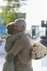 Paar mit Rosenstrauß umarmt — Stockfoto