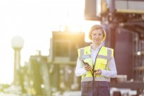 Portrait confident female air traffic controller with walkie-talkie on airport tarmac — Stock Photo