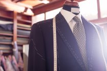 Крупный план костюма и рулетки на модели в магазине мужской одежды — стоковое фото
