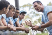 Team leader motivating team at boot camp obstacle course — Stock Photo
