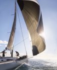 Wind zieht Segel auf Segelboot auf sonnigem Ozean — Stockfoto