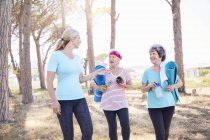 Yoga instructor talking to senior women after yoga class in park — Stock Photo