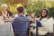 Portrait smiling woman drinking wine at garden lunch table — Stock Photo