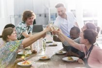 Chef profesor y estudiantes brindar copas de vino en la cocina de la clase de cocina - foto de stock
