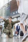 Hijo corriendo saludando madre soldado en el aeropuerto - foto de stock