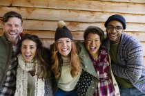 Portrait enthusiastic friends outside cabin — Stock Photo