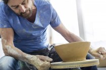 Mature man using pottery wheel in studio — Stock Photo