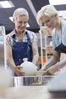 Женщины размещают керамику в печи в студии — стоковое фото