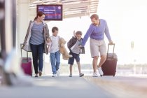 Family walking pulling suitcases at train station — Stock Photo