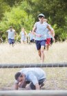 Persone che corrono sul campo di addestramento percorso ad ostacoli — Foto stock