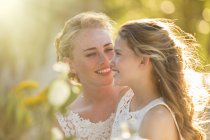 Невеста разговаривает с подружкой невесты в саду — стоковое фото