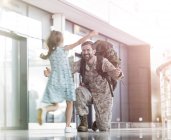 Дочь бежит и здоровается с отцом солдатом в зале ожидания аэропорта — стоковое фото