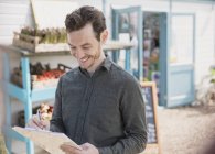 Smiling plant nursery worker with clipboard — Stock Photo