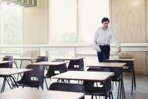 Professeur d'université collecte des tests sur les bureaux en salle de classe — Photo de stock