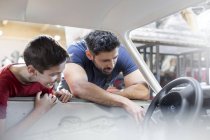 Отец и сын восстанавливают классический автомобиль — стоковое фото