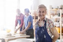 Portrait smiling senior woman in pottery studio — Stock Photo