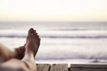 Perspectiva personal mujer descalza con arena a pie y vista al mar - foto de stock