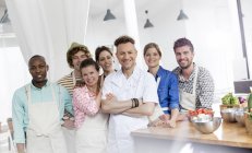 Portrait smiling chef teacher and students in cooking class kitchen — Stock Photo
