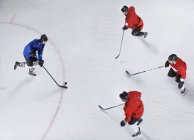 Защитники хоккея охраняют противника с шайбой на льду — стоковое фото