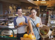 Couple shopping for oranges in market — Stock Photo