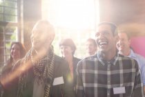 Hombres riéndose en audiencia en el centro comunitario - foto de stock