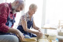 Coppia di anziani che utilizza ruote in ceramica in studio — Foto stock