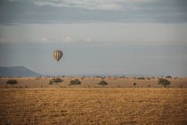 Hot hair balloon floating over tranquil desert, Serengeti, Tanzania — Stock Photo