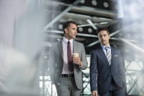Corporate businessmen walking with coffee — Stock Photo